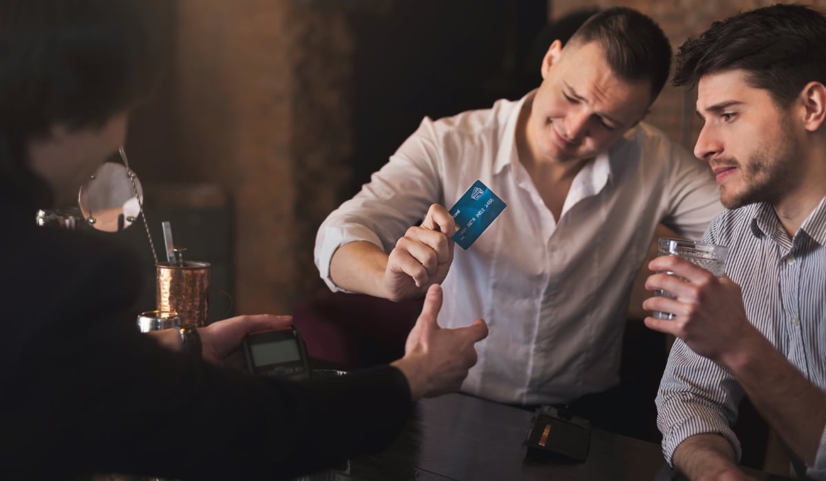 Mannen die met een kaart in een bar betalen mannen die met een kaart in een bar betalen
